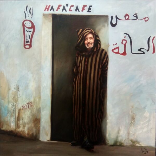 Personaje marroquí con chilaba a rayas, apoyado en una entrada en una pared blanca con el rótulo Ha Fa'Cafe