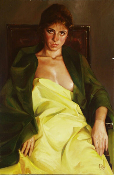 Chica sentada en sillón antiguo, tapada con pañuelo amarillo y chaqueta verde oscuro